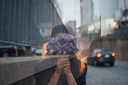 Une femme se cache derrière un bouquet de fleurs
